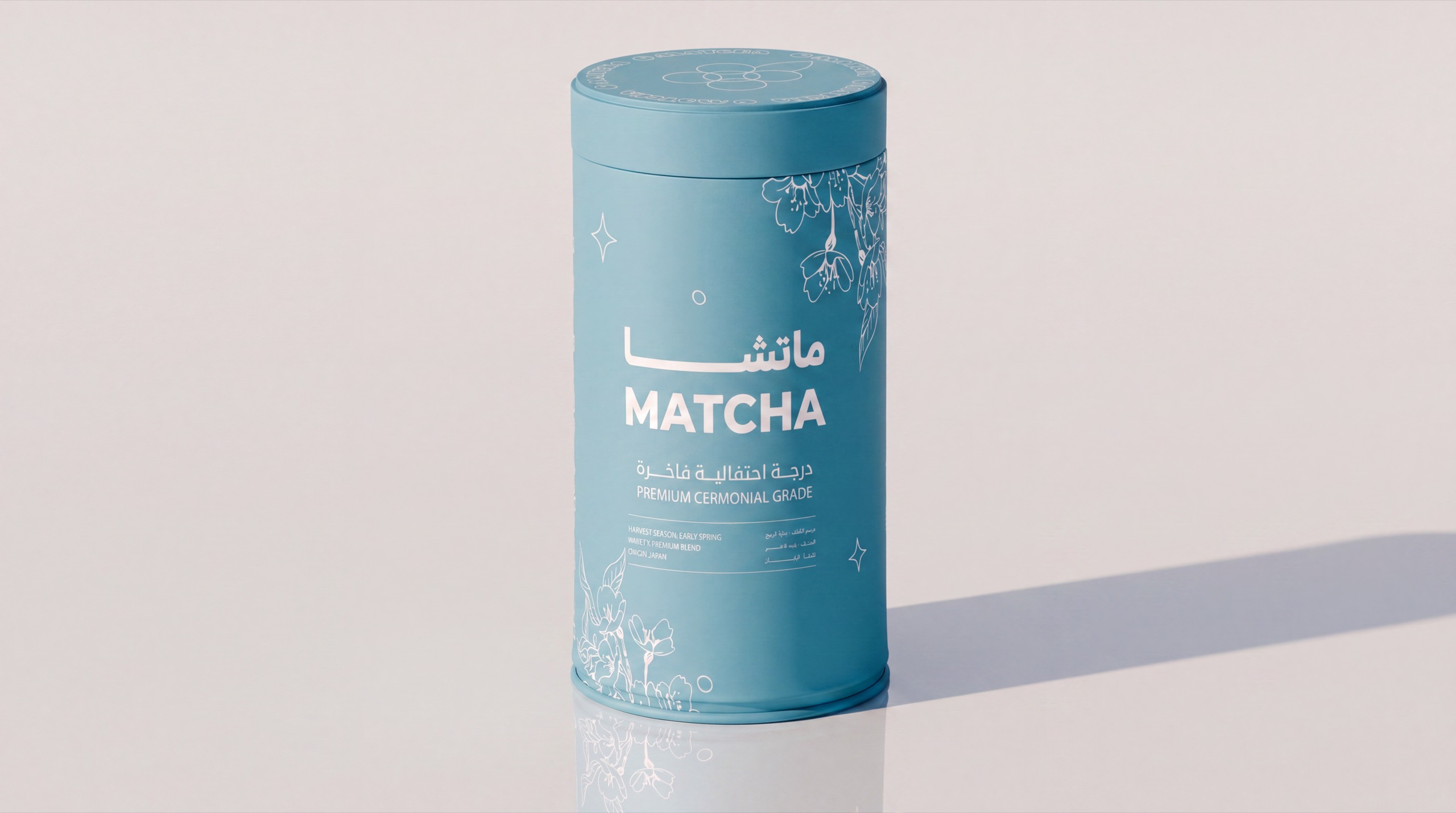 OMatcha — the same tin alone on a plain ground, and surrounded by cascading matcha powder — before
